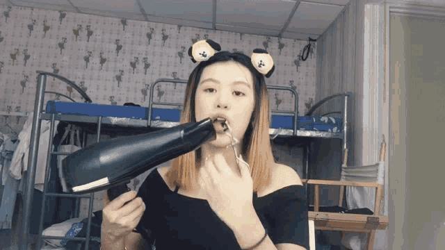 a woman is blow drying her hair while wearing a headband with ears on it