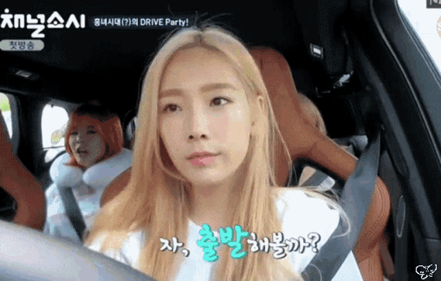 a girl with blonde hair is sitting in a car with another girl behind her .