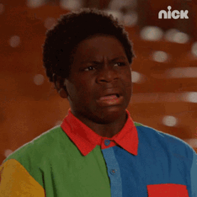 a young man wearing a colorful shirt is making a funny face with the nick logo in the background