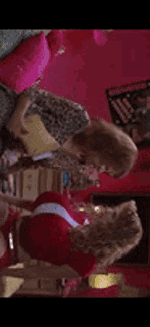 a woman in a leopard print dress is brushing her hair in a room with red walls .