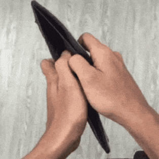 a person is holding an empty wallet with their hands .