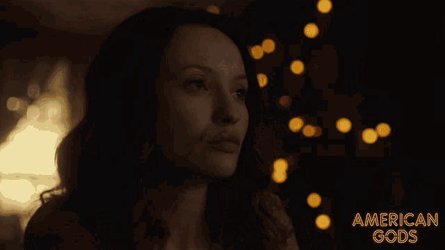 a woman in a dark room with the words american gods behind her