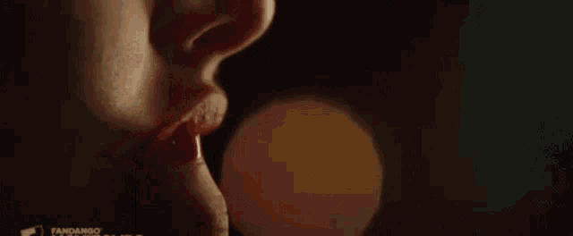 a close up of two women 's lips kissing each other in the dark .