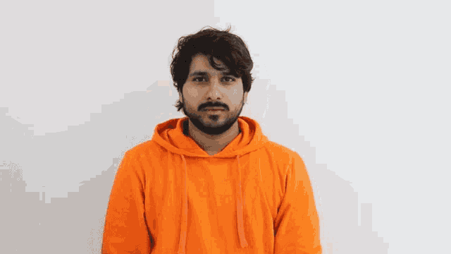 a man with a beard wearing a bright orange hoodie