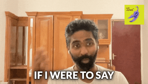 a man with a beard says " if i were to say " in front of wooden cabinets