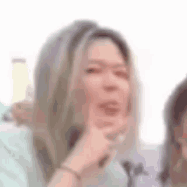 a close up of a woman making a funny face with her hand on her chin .