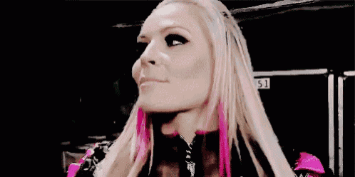 a close up of a woman 's face with pink hair