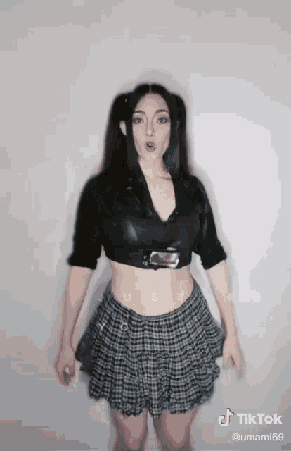 a woman wearing a plaid skirt and a black crop top has a tiktok account with the name umami69