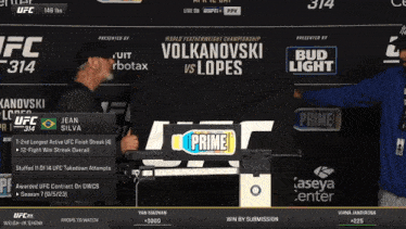 two men standing in front of a sign that says ufc 314