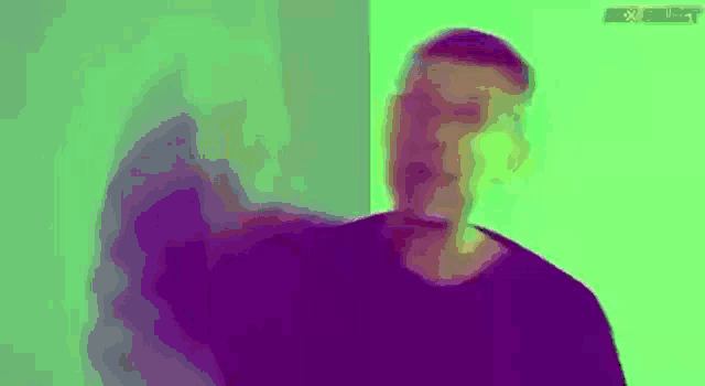 a man is standing in front of a green wall .