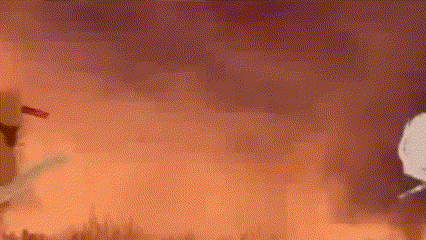 a painting of a person standing in front of a fire with a red sky in the background .