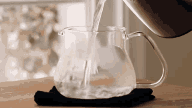 a pitcher of water is being poured into a cup