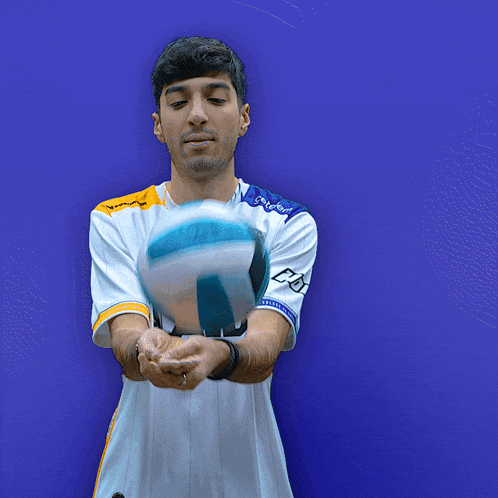 a man wearing a white ad jersey holds a volleyball in his hand