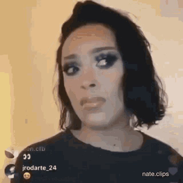 a close up of a woman 's face with black hair and makeup .