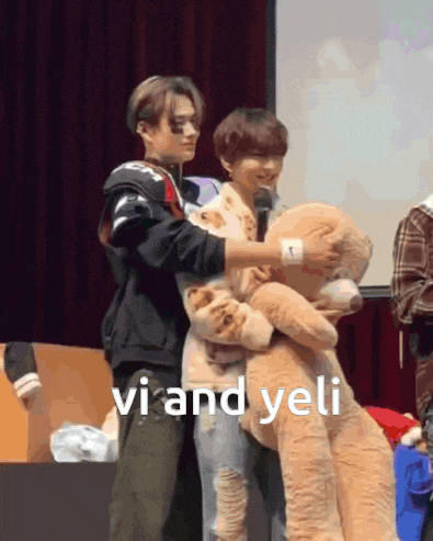 a person holding a teddy bear with the words vi and yeli written on the bottom
