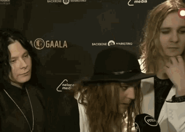 a group of people are standing in front of a wall that says gaala