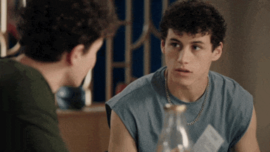 a man with curly hair is looking at another man with curly hair