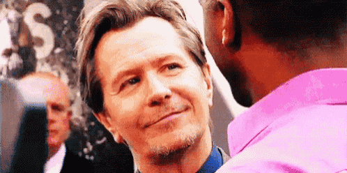 a man in a pink shirt is talking to another man in a pink shirt .
