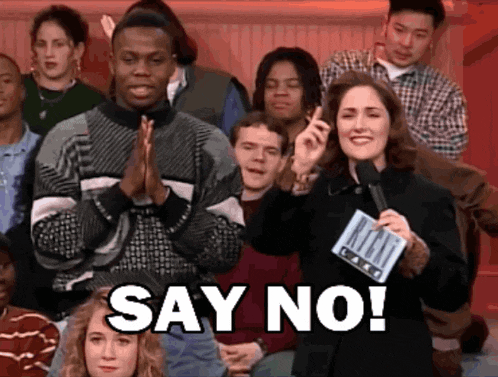 a woman holding a microphone in front of a crowd says " say no "