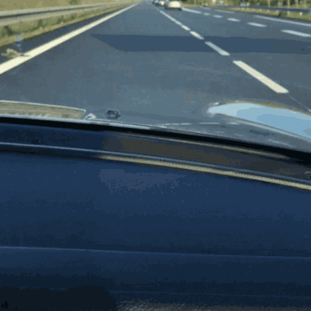 a car is driving down a highway and the dashboard is visible