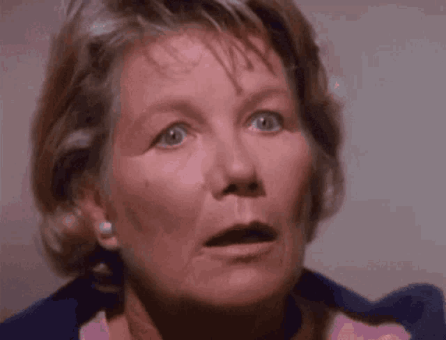 a close up of a woman 's face with a surprised expression .