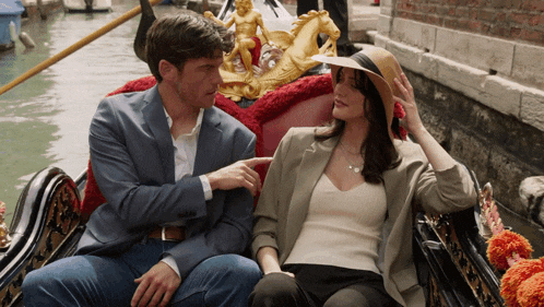 a man and a woman are sitting in a gondola looking at each other