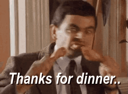 a man in a suit and tie is eating chicken wings and says thanks for dinner .