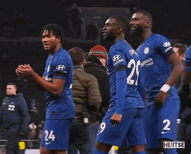 two soccer players wearing blue jerseys with the number 29 and 24 on them