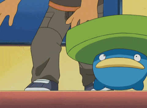 a person standing next to a blue duck with a green hat on