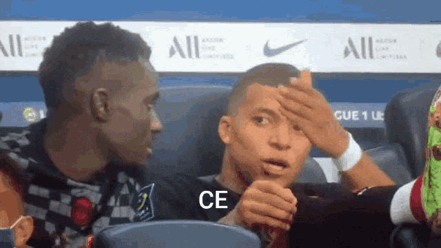 a soccer player holds his hand to his forehead in front of a banner that says ce