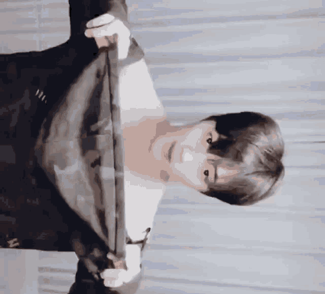 a man is holding a piece of cloth in his hands and looking down .