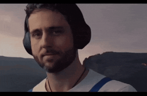 a man with a beard is wearing headphones and smiling .