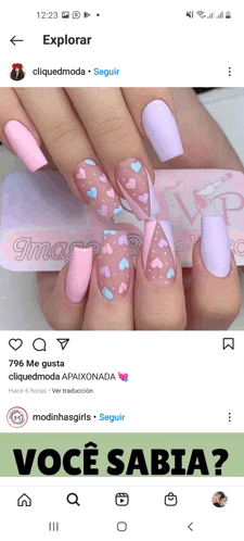 a screenshot of a woman 's nails with hearts and the words você sabia at the bottom