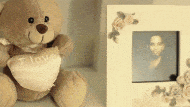 a teddy bear is holding a heart that says i love you