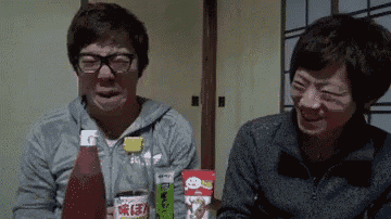 a man and a woman are sitting at a table with bottles of ketchup and a bag of ketchup .