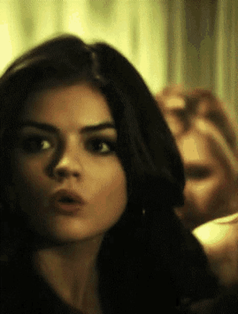 a close up of a woman 's face with a surprised expression