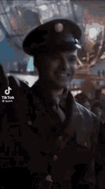a man in a military uniform is smiling in a crowd of people .
