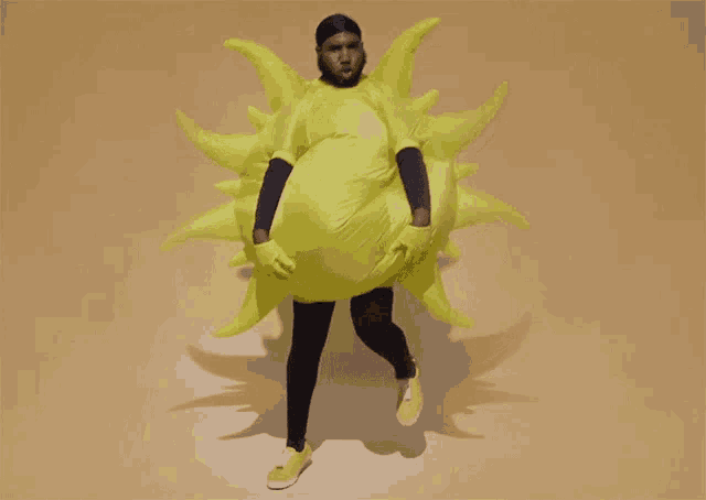 a man is wearing a yellow inflatable sun shaped costume