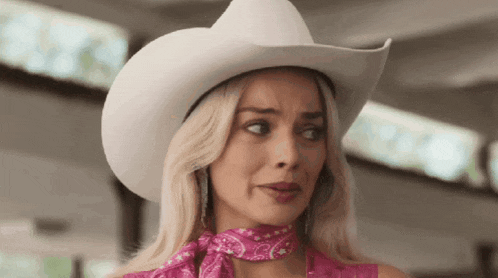 a woman wearing a white cowboy hat and a pink bandana .