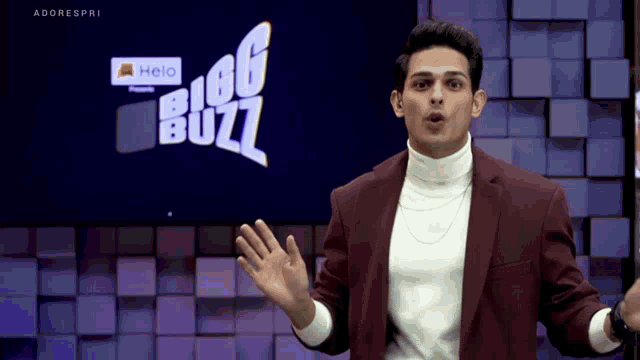a man in a suit stands in front of a big buzz logo