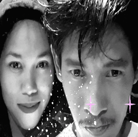 a man and a woman are posing for a picture with snow falling on them