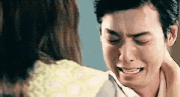 a man is crying while holding a woman 's neck .