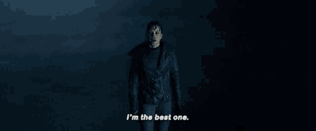 a woman in a black jacket is standing in the dark and says i 'm the best one