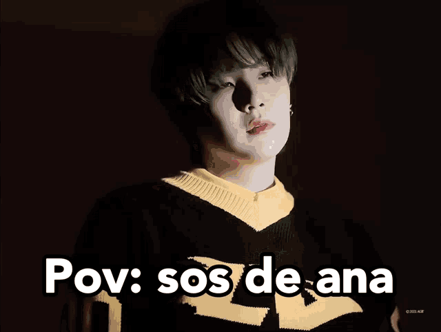 a man wearing a black and yellow sweater with the words pov sos de ana on the bottom