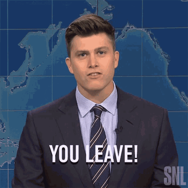 a man in a suit and tie says you leave in front of a map