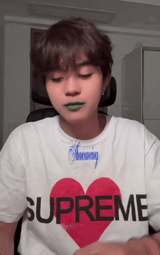 a person wearing a supreme shirt with a heart on it