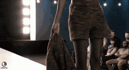 a woman walking down a runway with a lifetime logo in the background