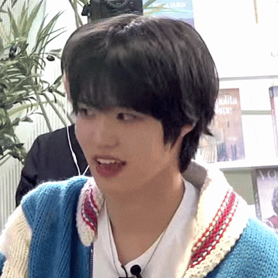 a young man wearing a blue and white sweater and a white t-shirt