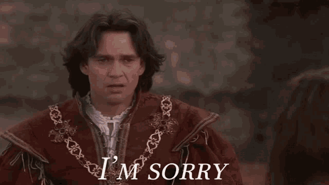 a man in a costume says i 'm sorry in front of a woman