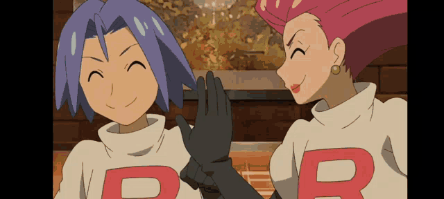 a man and a woman are standing next to each other wearing sweaters with the letter b on them